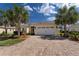 Charming home exterior with a brick driveway and lush landscaping at 5007 Belted Kingfisher Dr, Oxford, FL 34484