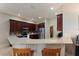 Modern kitchen featuring a breakfast bar, stainless steel appliances, and dark wood cabinets at 5007 Belted Kingfisher Dr, Oxford, FL 34484