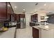 Gourmet kitchen featuring dark wood cabinetry, stainless steel appliances, and granite countertops at 5007 Belted Kingfisher Dr, Oxford, FL 34484