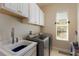 Well-lit laundry room with modern appliances and a utility sink, offering convenience and functionality at 5007 Belted Kingfisher Dr, Oxford, FL 34484