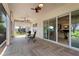 Screened patio featuring herringbone tile, ceiling fans, and access to the home's interior at 5007 Belted Kingfisher Dr, Oxford, FL 34484