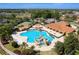 Aerial view of a resort-style community pool with a rock feature and clubhouse at 5007 Belted Kingfisher Dr, Oxford, FL 34484