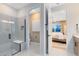 Modern bathroom with a glass shower and tiled walls, toilet, and doorway into the main bedroom at 5166 Gardenrow Dr, St Cloud, FL 34772