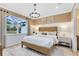 Cozy bedroom with a large window, elegant chandelier, and a neutral color palette at 5166 Gardenrow Dr, St Cloud, FL 34772