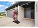 Welcoming front entrance with a gray door, stylish black trim, and vibrant red plants at 5334 Mary Ann Ln, Orlando, FL 32810
