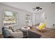 Bright living room featuring wood floors, modern ceiling fan, and natural light from the large windows at 5334 Mary Ann Ln, Orlando, FL 32810