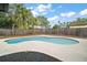 Large backyard with a beautiful pool surrounded by a concrete patio and lush greenery at 5334 Mary Ann Ln, Orlando, FL 32810