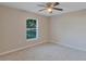 A cozy carpeted bedroom offers natural light and a ceiling fan at 57 Pine Trace Crse, Ocala, FL 34472