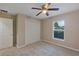 Comfortable carpeted bedroom features ceiling fan, natural light and closet at 57 Pine Trace Crse, Ocala, FL 34472