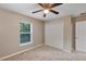 Comfortable carpeted bedroom features ceiling fan, natural light and closet at 57 Pine Trace Crse, Ocala, FL 34472