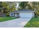 Single-story home with two car garage featuring a concrete driveway and well manicured lawn at 57 Pine Trace Crse, Ocala, FL 34472