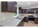 Close up of the kitchen, showing countertops, faucet, stainless steel appliances, and dark wood cabinets at 57 Pine Trace Crse, Ocala, FL 34472