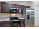 Kitchen featuring stainless steel appliances and dark wood cabinets at 57 Pine Trace Crse, Ocala, FL 34472