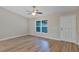Well-lit living area with wood-style flooring, a ceiling fan and a large window at 57 Pine Trace Crse, Ocala, FL 34472