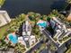 Aerial view of luxurious community featuring pools, landscaping, lake, and parking at 6165 Carrier Dr # 2001, Orlando, FL 32819
