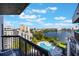 Balcony overlooking a large lake and community pool with nearby buildings and lush tropical landscape at 6165 Carrier Dr # 2001, Orlando, FL 32819