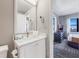 Modern bathroom with quartz countertop, stylish fixtures, and doorway to bedroom at 6165 Carrier Dr # 2001, Orlando, FL 32819