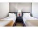 Well-lit bedroom featuring two beds, stylish side tables, and neutral decor at 6165 Carrier Dr # 2001, Orlando, FL 32819
