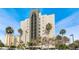 Modern condo building showcasing balconies and palm trees against a clear blue sky at 6165 Carrier Dr # 2001, Orlando, FL 32819