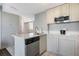 Bright kitchen featuring white cabinetry, stainless steel dishwasher, and tile floor at 6165 Carrier Dr # 2001, Orlando, FL 32819