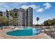 Large swimming pool at the base of a multi-story building with balconies at 6165 Carrier Dr # 2001, Orlando, FL 32819