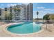 Stunning, curvaceous outdoor pool with lounge chairs and a view of the building at 6165 Carrier Dr # 2001, Orlando, FL 32819