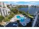 Aerial view of the beautiful community pool, adjacent spa, lounge chairs, and verdant landscaping near the lake at 6165 Carrier Dr # 2001, Orlando, FL 32819