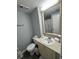 Clean bathroom with a single sink vanity, toilet, and shower featuring a new shower curtain at 6165 Carrier Dr # 3104, Orlando, FL 32819