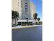 Building entrance with palm trees and electric scooters out front at 6165 Carrier Dr # 3104, Orlando, FL 32819
