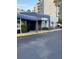 Building entrance with guest registration sign, covered canopy, and well-maintained landscaping at 6165 Carrier Dr # 3104, Orlando, FL 32819