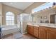 Bathroom featuring a soaking tub, glass shower, and a dual sink vanity at 625 Waterland Ct, Orlando, FL 32828