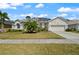 Beautifully landscaped home with lush lawn, mature palm, and a paved driveway to the two-car garage at 625 Waterland Ct, Orlando, FL 32828