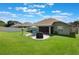 A beautiful backyard boasts a well-manicured lawn and patio with table, grill and umbrella for outdoor relaxation at 743 Lake Douglas Dr, Groveland, FL 34736
