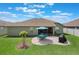 A beautiful backyard boasts a well-manicured lawn and patio with table, grill and umbrella for outdoor relaxation at 743 Lake Douglas Dr, Groveland, FL 34736