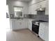 Modern kitchen with white cabinetry, stainless steel appliances, and stylish backsplash at 769 Avenue Q Se, Winter Haven, FL 33880