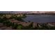 Aerial view of residences near a lake, enhanced by the backdrop of a city skyline at night at 8161 Via Rosa, Orlando, FL 32836