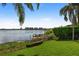 Green backyard features a fence overlooking the water, dock, and community off in the distance at 8161 Via Rosa, Orlando, FL 32836