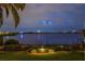 Manicured backyard view at night with landscape lighting and stunning lake views at 8161 Via Rosa, Orlando, FL 32836