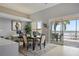 Bright dining area with a desk, contemporary art, and sliding glass doors to a tiled patio and water view at 8161 Via Rosa, Orlando, FL 32836