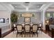 Elegant dining room with tray ceiling, decorative lighting fixture and seating for eight around the wooden table at 8161 Via Rosa, Orlando, FL 32836