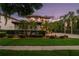 Elegant two-story home featuring lush landscaping, a red tile roof, and a circular driveway at 8161 Via Rosa, Orlando, FL 32836