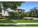 Charming two-story home showcasing lush landscaping, a red tile roof, and a circular driveway at 8161 Via Rosa, Orlando, FL 32836