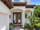 Elegant front entryway with leaded glass double doors and manicured landscaping at 8161 Via Rosa, Orlando, FL 32836