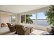 Sitting area with two armchairs, large windows providing beautiful water and palm tree views at 8161 Via Rosa, Orlando, FL 32836
