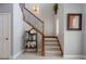 Traditional staircase with wood railing, decorative iron spindles, neutral carpet and large potted plants at 8161 Via Rosa, Orlando, FL 32836