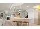 Well-lit kitchen and living area with bar seating, modern appliances, and staircase nearby at 901 S Atlantic Ave # 3, Ormond Beach, FL 32176