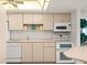 Efficient kitchen with white appliances and warm-toned cabinets, offering ample storage and counter space at 901 S Atlantic Ave # 3, Ormond Beach, FL 32176