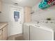 Functional laundry room with modern washer and dryer, storage cabinets, and utility sink at 901 S Atlantic Ave # 3, Ormond Beach, FL 32176