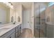 Bathroom featuring double sinks, a walk-in shower with glass doors, modern fixtures and tile floors at 9763 Brown Burrow St, Orlando, FL 32829