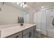 Bright bathroom featuring a large mirror, white countertop, and a shower-tub combination with neutral finishes at 9763 Brown Burrow St, Orlando, FL 32829